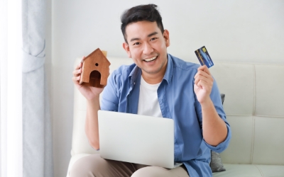 Seorang pria memegang kartu kredit dan miniatur rumah (www.freepik.com)